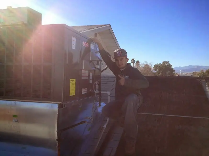 HVAC technician performing AC Tune-Up on a rooftop unit in Glenville